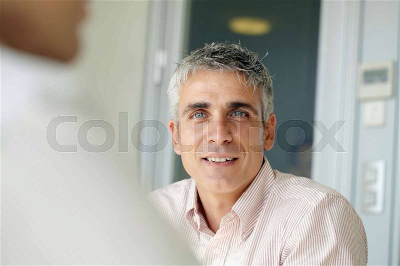 Older business man in meeting, stock photo