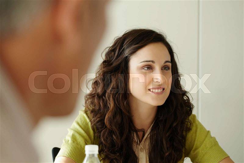 Portrait of young woman in meeting, stock photo