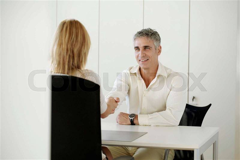 Older man and woman shaking hands, stock photo