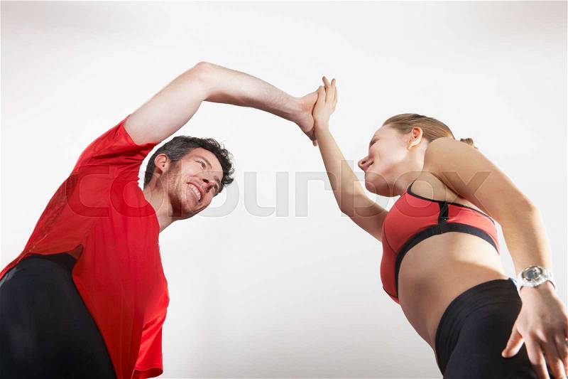 Couple in running gear high fiving, stock photo