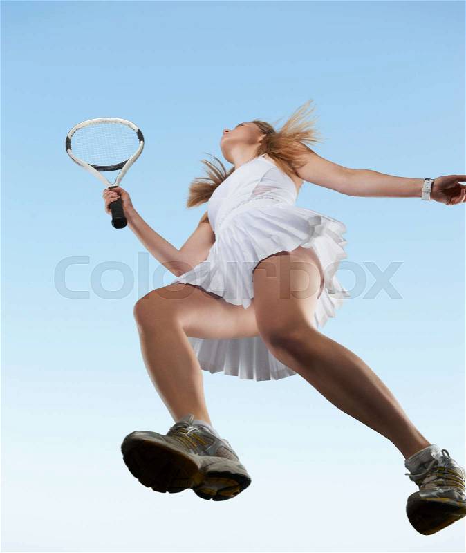 Low angle view of woman playing tennis, stock photo