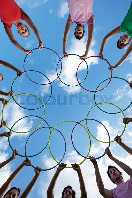People holding hula hoops in circle, stock photo