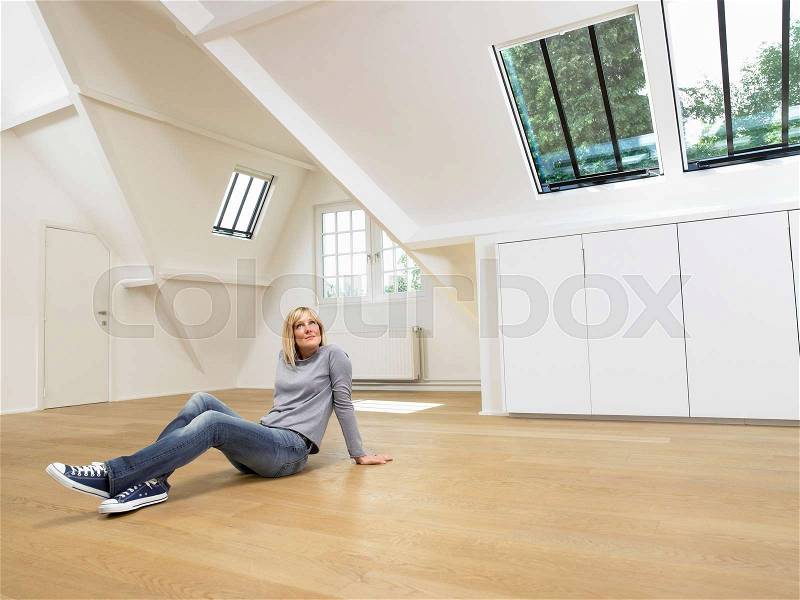 Woman seated on wooden floor, stock photo