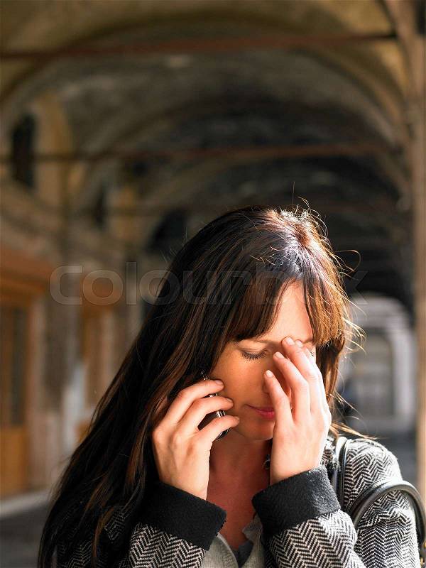Crying woman talking on mobile phone, stock photo