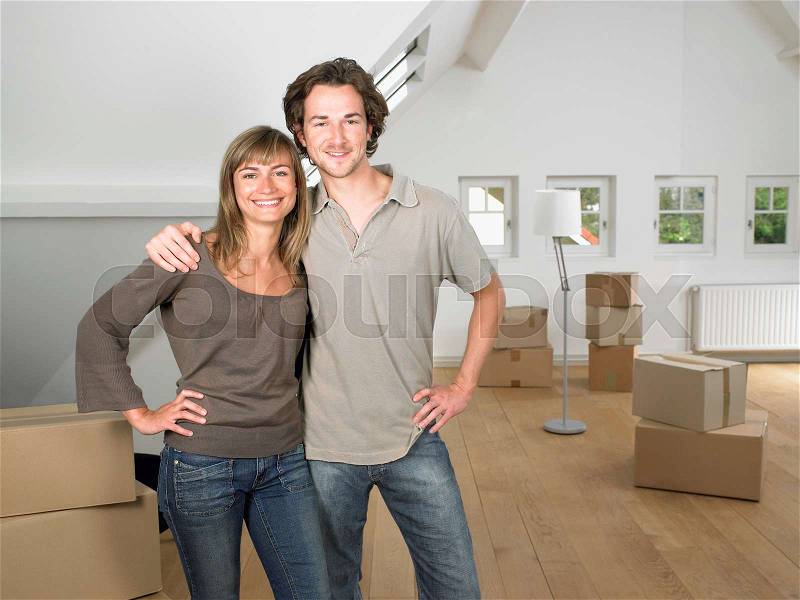 Couple moving into new home smiling, stock photo