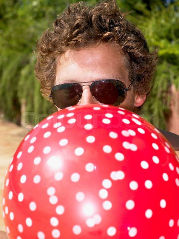 Man blowing up a balloon, stock photo