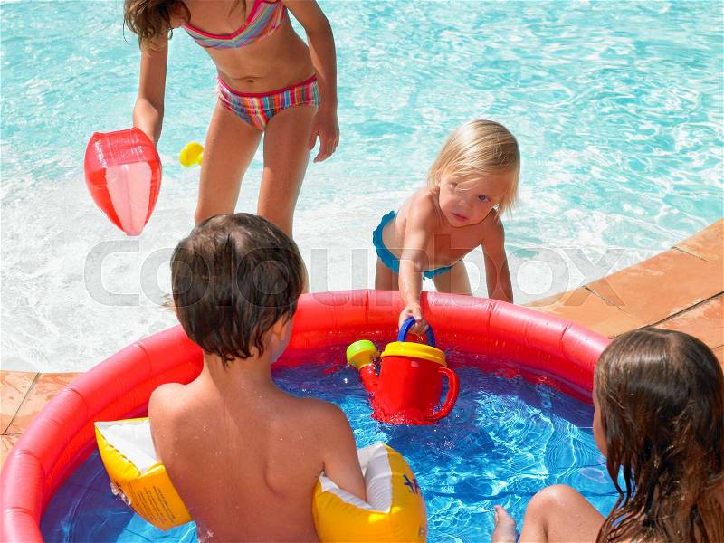 Four children playing in a kiddie pool, stock photo