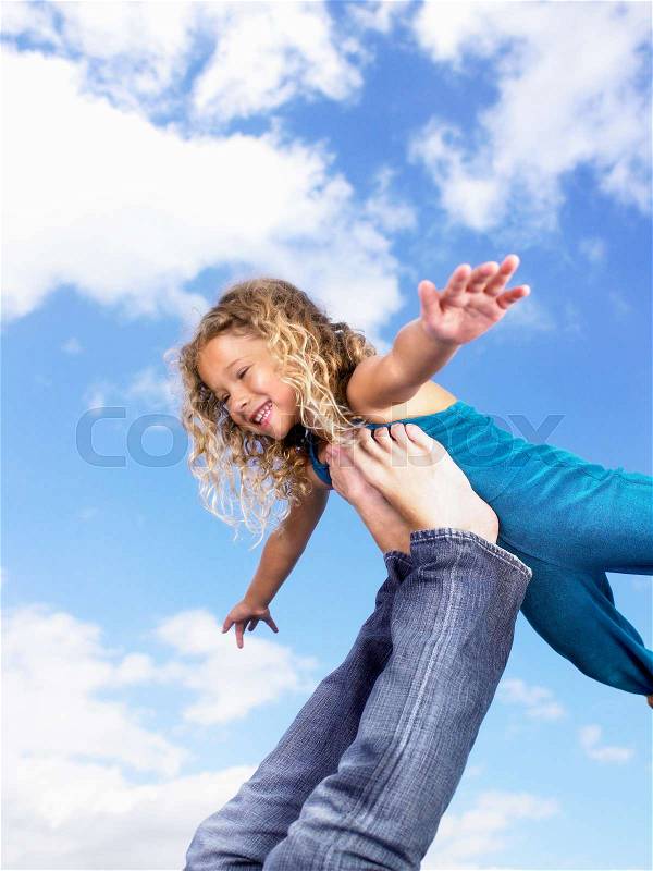 Young girl swirling feet in the air, stock photo