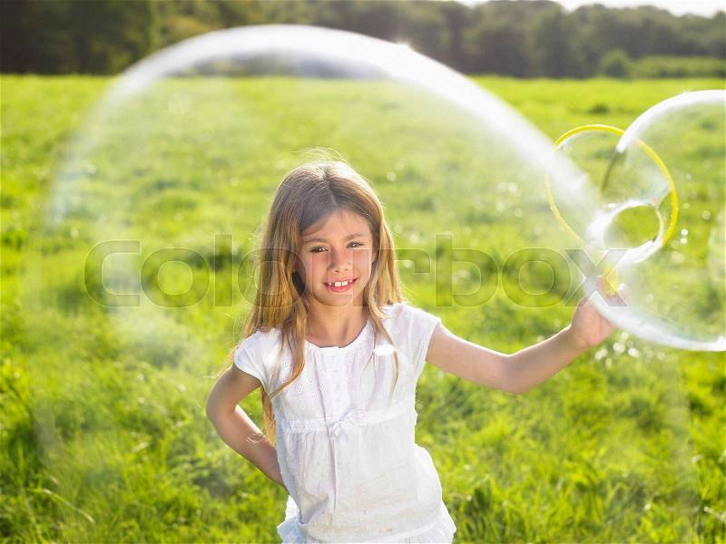 Little girl making soap bubbles, stock photo