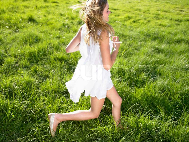 Young woman running in a field, stock photo