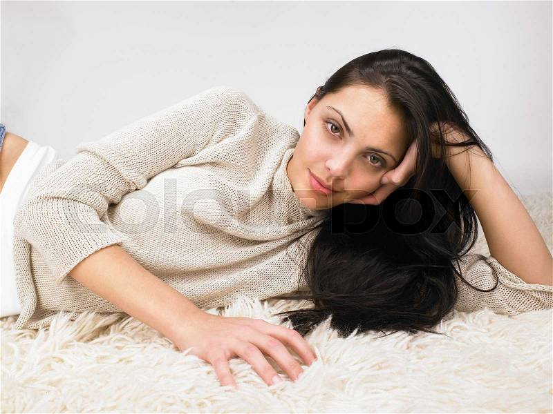 Woman laying on the floor smiling, stock photo