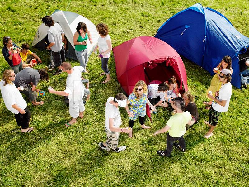 Group partying outside tents, stock photo