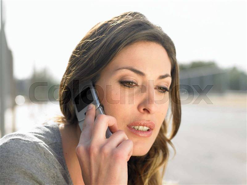 Close up of young woman on mobile phone, stock photo