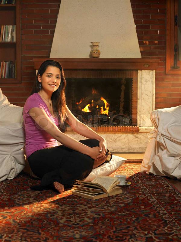 Young woman sitting on rug, stock photo