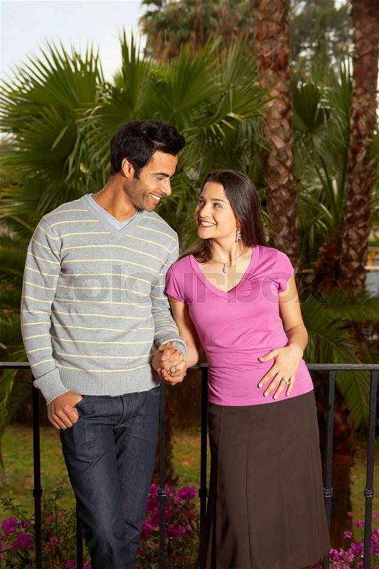 Young couple holding hands on balcony, stock photo