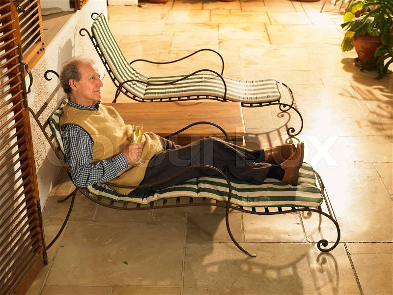Senior Adult man lying on sun lounger, stock photo