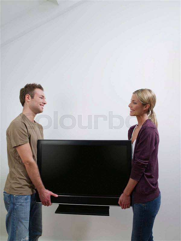 A couple carrying a tv, stock photo