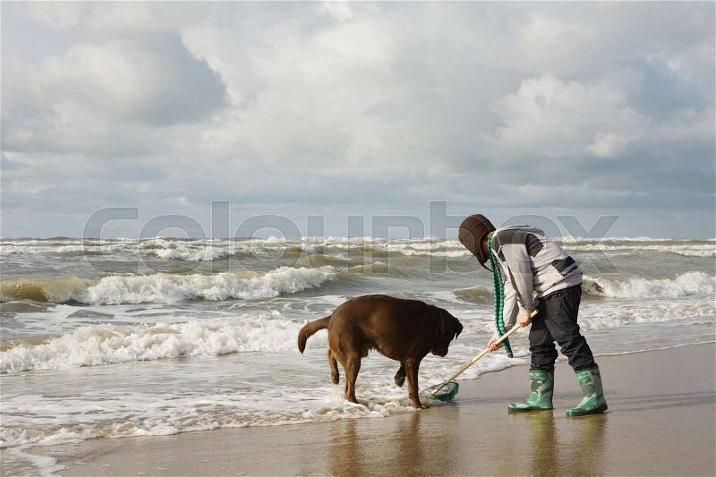 Boy by sea with dog, stock photo