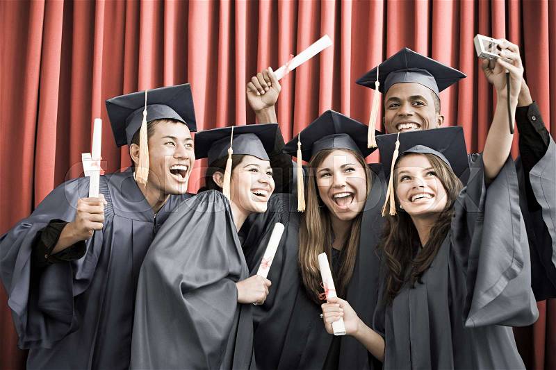 Graduating friends with camera, stock photo