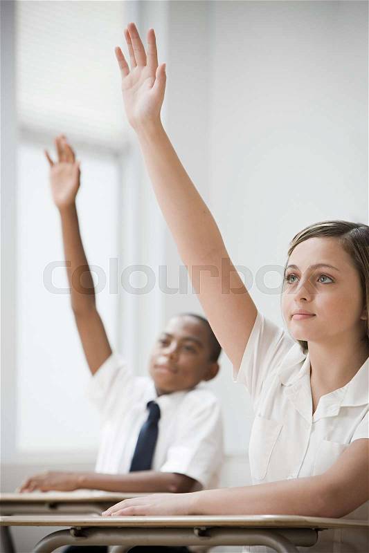 School students with hands raised, stock photo
