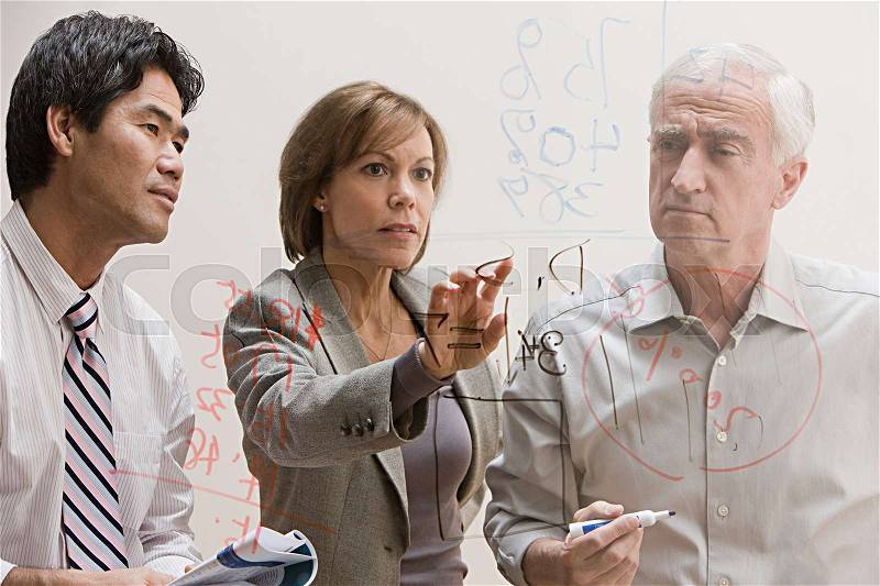 People looking at diagram on glass wall, stock photo