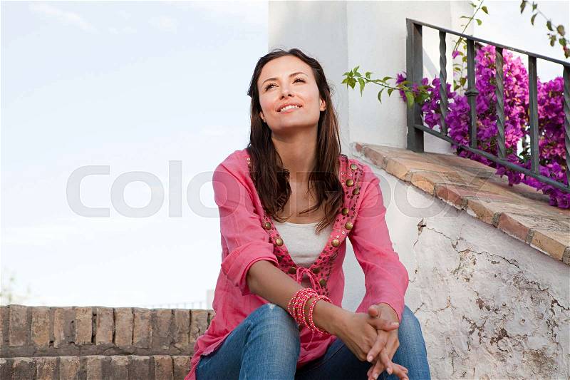Young woman sitting on steps, stock photo