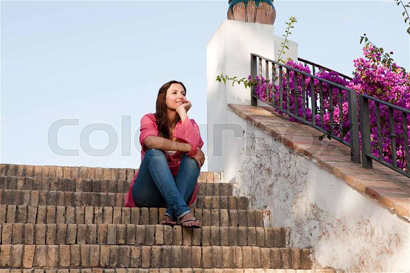 Young woman sitting on steps, stock photo