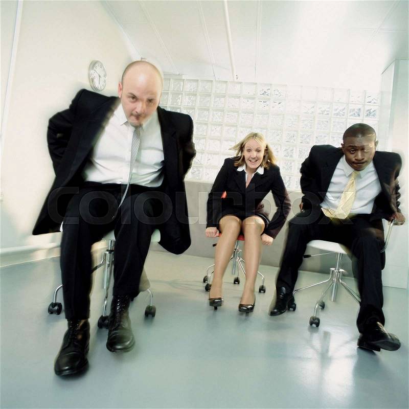 Businesspeople fooling around on chairs, stock photo