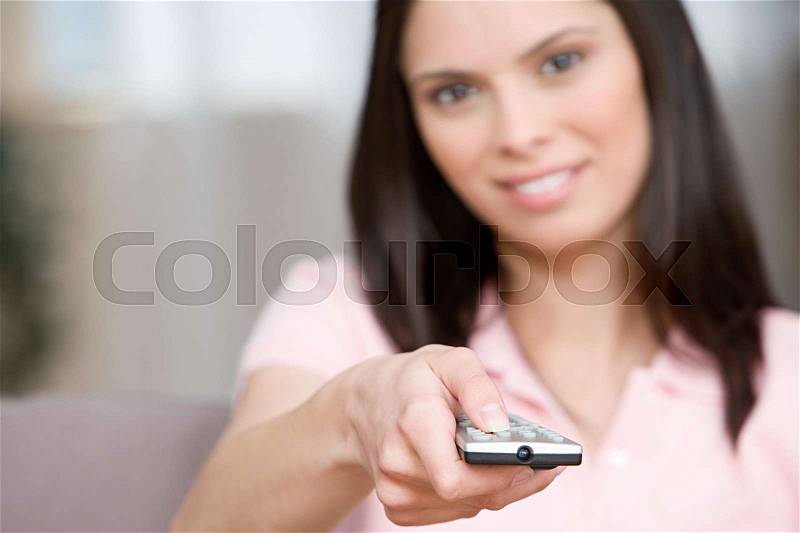 Young woman with remote control, stock photo