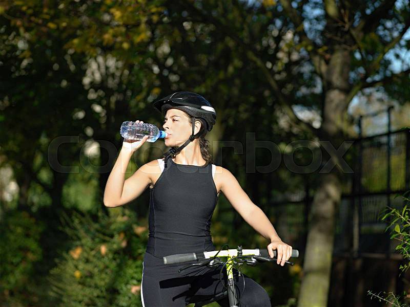Cyclist drinking water, stock photo