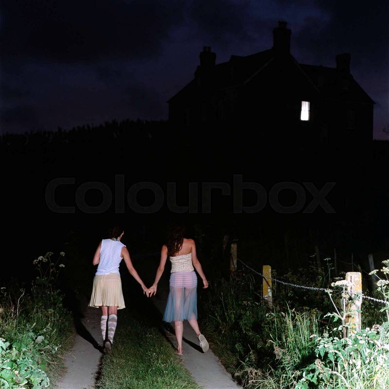Girlfriends walking at night, stock photo