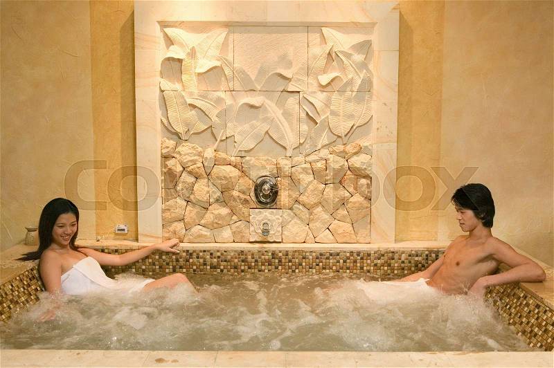 Young couple relaxing in hot tub, stock photo