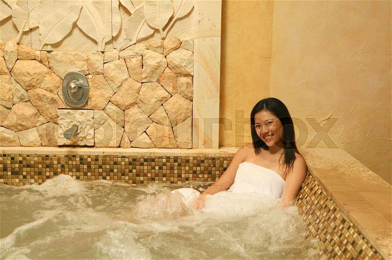 Smiling woman in hot tub, stock photo