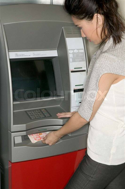 Woman using a cash machine, stock photo