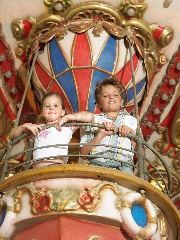 Brother and sister on a fairground ride, stock photo