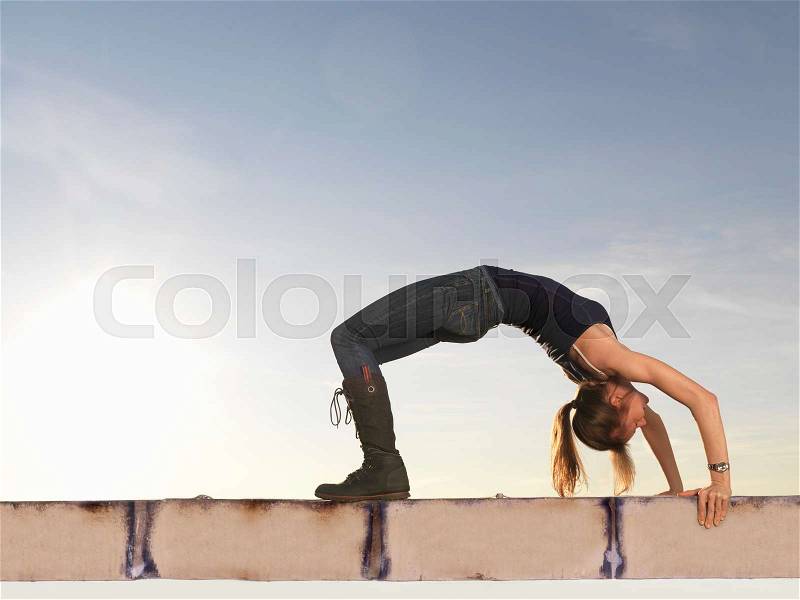 Woman bending backwards into arch, stock photo