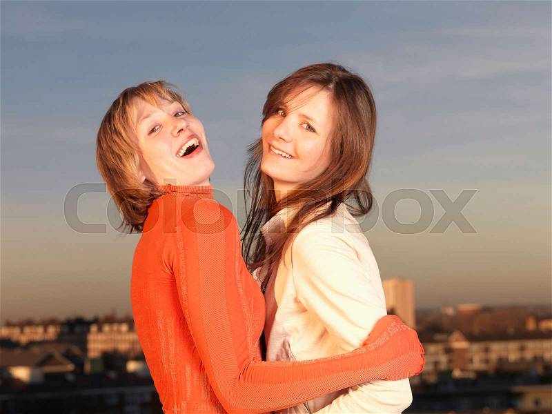 Two women hugging, laughing, stock photo