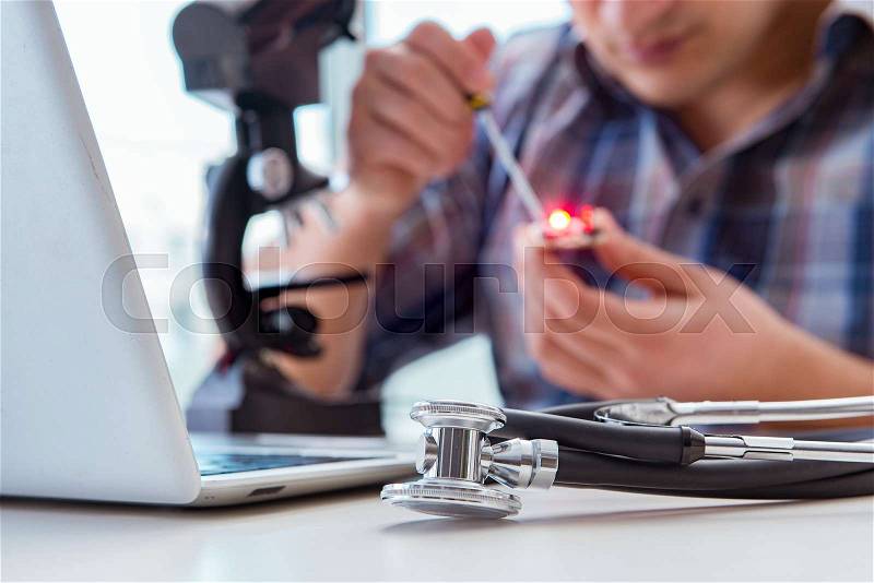 High precision engineering with man working with microscope, stock photo