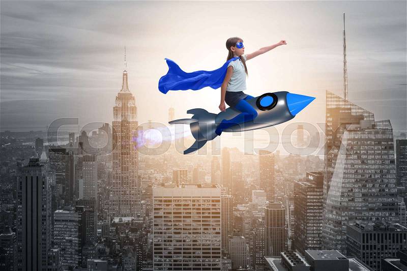 Little girl flying rocket in superhero concept, stock photo