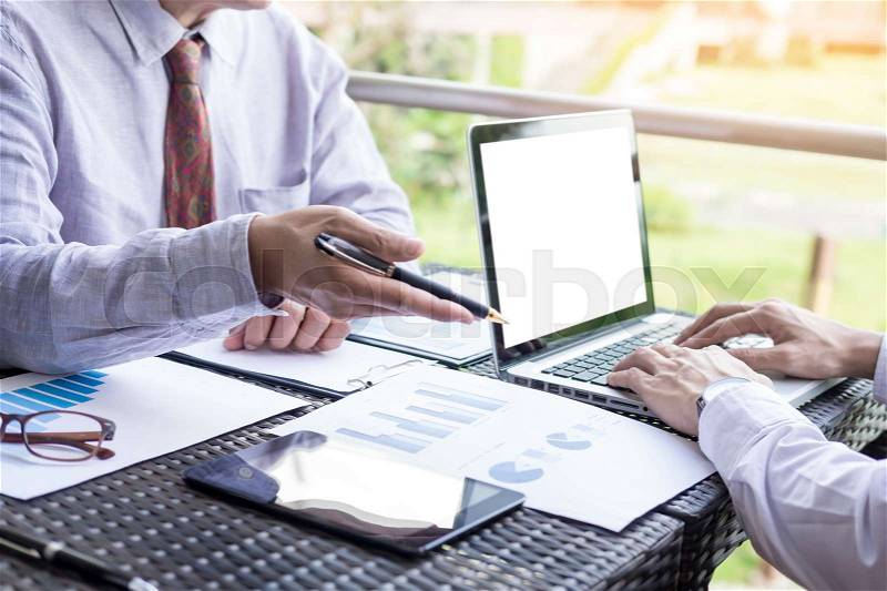 Business people discuss together about there work by graph document and setting in outdoor for planning financial strategy, stock photo