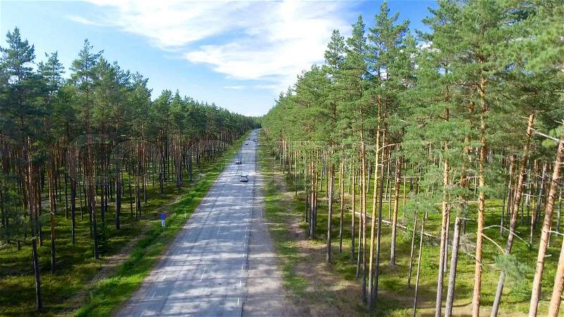 Aerial view of beautiful road across the forest, stock photo