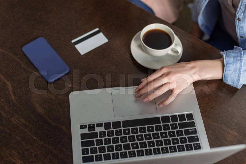 Overhead view of working desk with person using laptop computer, stock photo