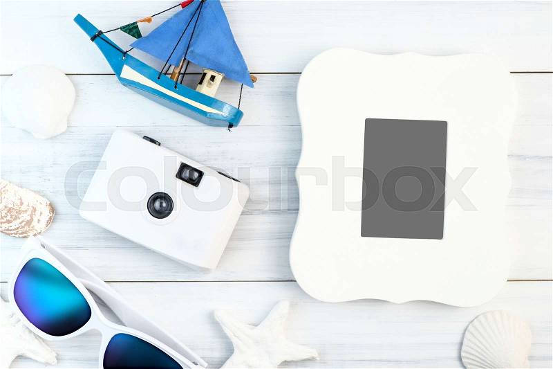 Beach accessories (White sunglasses,starfish,camera,boat,shell) and vintage white paper card on white plaster wood table top view,Summer vacation concept, stock photo