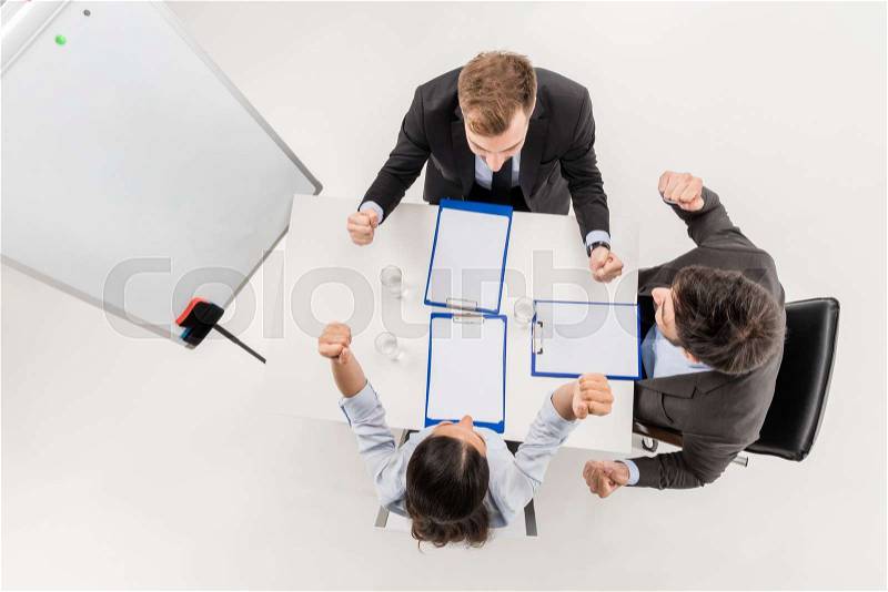 Overhead view of excited business people celebrating triumph during discussion at meeting isolated on white, stock photo
