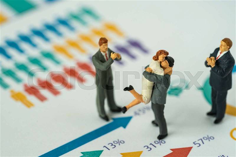 Miniature people with couple standing on printed gender report as couple life style analysis concept, stock photo