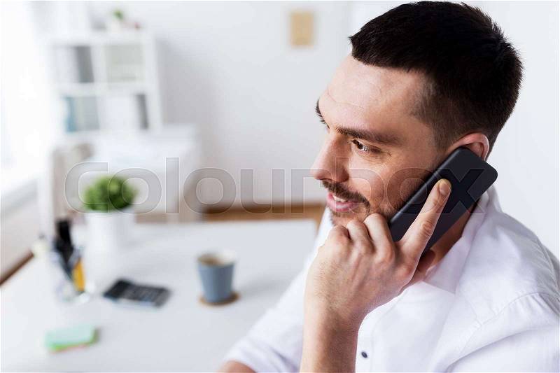 Business, people, communication and technology concept - businessman calling on smartphone at office, stock photo