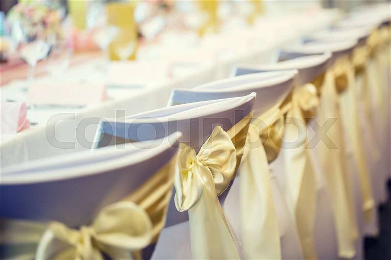 Wedding. Wedding chairs in row decorated with golden yellow color ribbon, stock photo