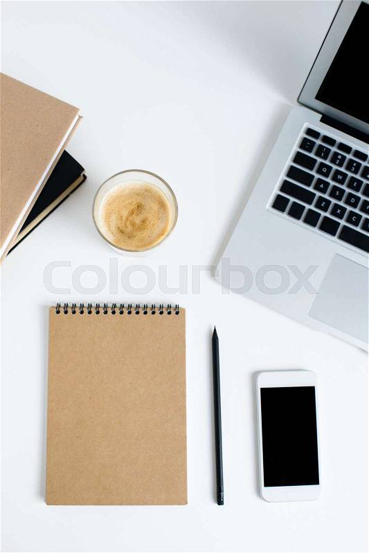 Top view of laptop, smartphone, notepad, books and glass of coffee, isolated on white, stock photo