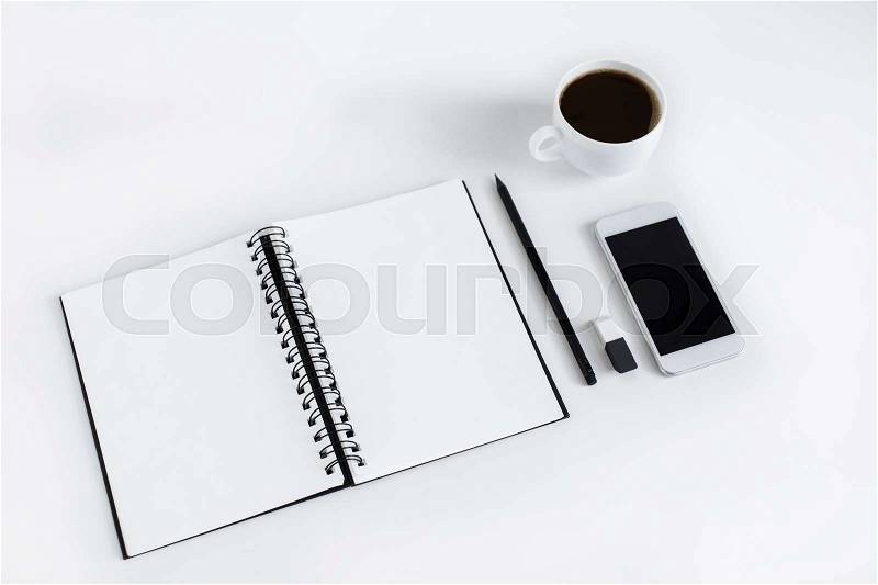 Empty notepad, smartphone and cup of coffee, isolated on white, stock photo