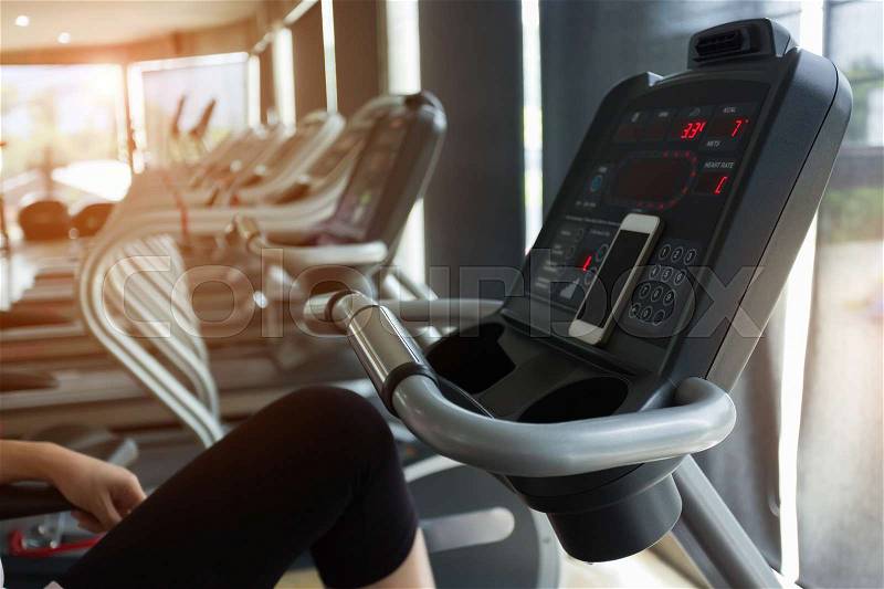 Woman cycling burn fat on bicycle cardio machine in fitness gym exercise sport club center, stock photo